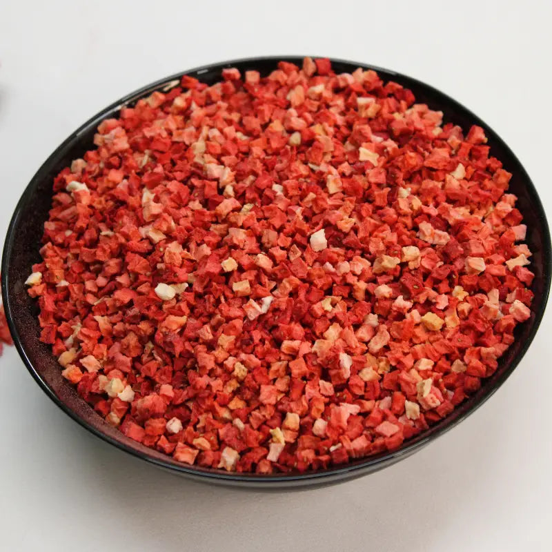 Freeze-dried strawberry pieces served in a black ceramic bowl